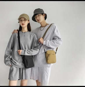 Close-up of lightweight nylon crossbody bag paired with casual gray sportswear outfit