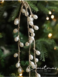 Close-up of champagne gold Christmas berry stems with glitter hanging on a festive tree