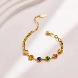Detail of gold-plated stainless steel chain bracelet with colorful cat eye gemstones