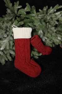 Close-up of red and white cable knit Christmas stockings with pine cones and frosty branches