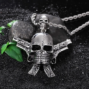Detailed shot of silver punk skull pendant with dual pistols on dark textured background