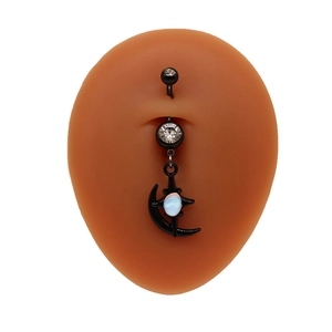 Détail du piercing de nombril noir avec lune, étoile et opale sur un modèle en silicone