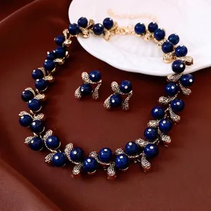 Vintage gold jewelry set with deep blue resin gemstones and rhinestone leaf accents