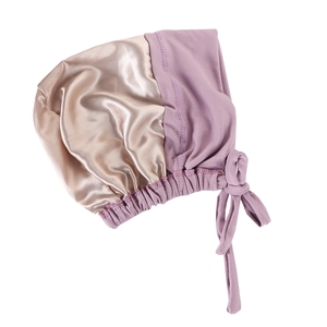 Detail of satin bonnet showing purple and gold silk fabric with adjustable drawstrings