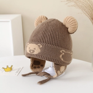 Close-up of knit winter hat with plush bear ears and cozy earflap detail