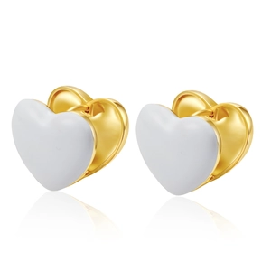 Detailed macro view of heart-shaped gold and white enamel hoop earrings on white background