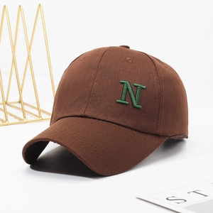 Brown cotton baseball cap with green embroidered N letter on clean grey background