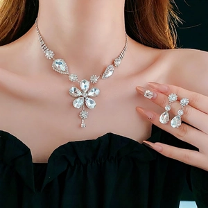 Elegant floral rhinestone necklace and earring set displayed on model in soft lighting