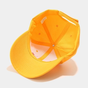 Détail intérieur d'une casquette jaune montrant les coutures et l'étiquette d'entretien