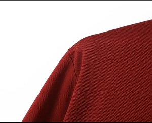 Detailed macro view of burgundy knit polo shirt shoulder seam and breathable pique texture