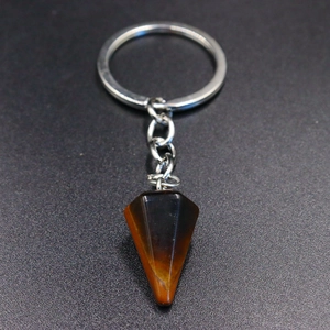 Macro detail of natural tiger eye stone hexagonal pendant on silver keychain