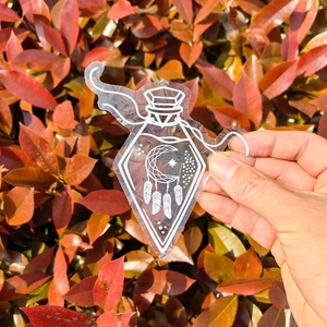 Close-up of potion bottle suncatcher sticker with dreamcatcher design in natural light