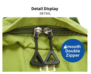 Macro shot of smooth dual metal zippers and white embroidery on the green nylon backpack