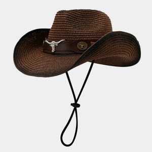 Detail of western cowboy straw hat featuring a metal bull head ornament and leather band