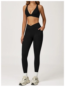 Detail of high-waisted black yoga leggings with V-shaped waistband and side pockets