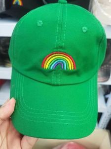 Close-up of bright green cotton baseball cap featuring colorful rainbow embroidery on front