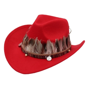 Detail of red wool felt cowboy hat with ethnic feathers, beads and metal coin ornaments