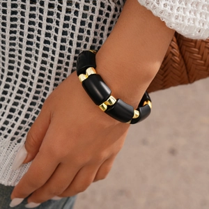 Close-up of matte black cylindrical beads and gold spacers on a chunky ethnic bracelet