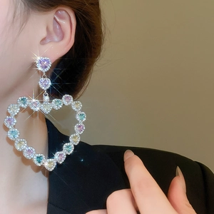 Gros plan sur des boucles d'oreilles cœur avec cristaux colorés et finition brillante