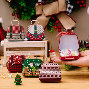 Detailed view of open Christmas tin handbag boxes filled with colorful candies and gifts