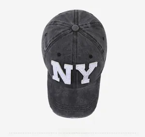 Close-up of black washed denim baseball cap with white NY embroidery and distressed brim