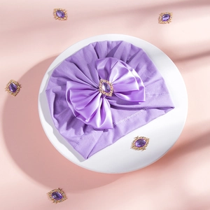 Detail of soft purple baby turban with large satin bow and rhinestone center