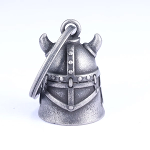 Detail of vintage silver Viking helmet bell with intricate embossed texture and ring hook