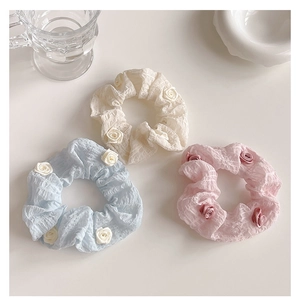 Detailed shot of camellia scrunchies in cream, blue and pink with floral accents