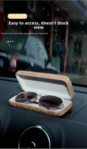 Detailed view of champagne rhinestone car glasses box with sunglasses on dashboard