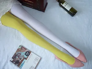 Détail de collants en velours jaune et blanc portés avec des ballerines en daim rose