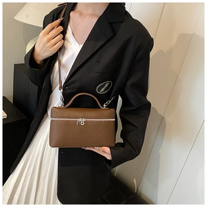 Brown box bag with lychee grain texture shown on model with shoulder strap