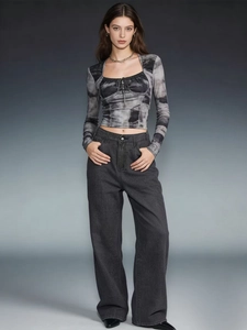 Detail of high-waisted wide-leg denim jeans with tie-dye long sleeve cropped top outfit