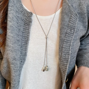 Close-up of adjustable Y-shaped necklace with silver-tone teardrop and spotted stone charms