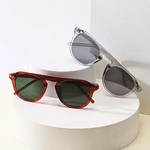 Retro square frame sunglasses with amber and clear grey acetate frames on stone display