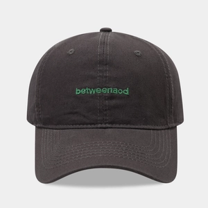 Detail of dark grey cotton baseball cap featuring green betweenaod embroidery and stitching
