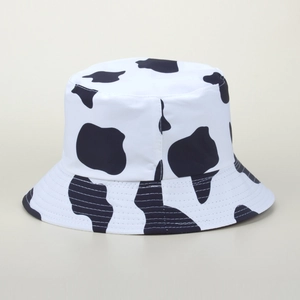 Gros plan détaillé du motif vache et des coutures d'un chapeau bob en toile