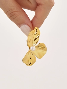 Detail von goldenen Blütenohrringen mit weißer Perle, in der Hand auf weißem Hintergrund