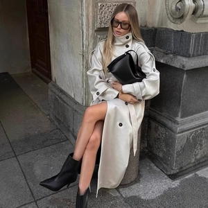 Women's chic cream high collar trench coat in glossy faux leather with a long belt