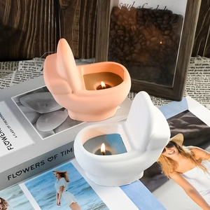 Close-up of creative toilet shaped scented candles in pink and white ceramic bases