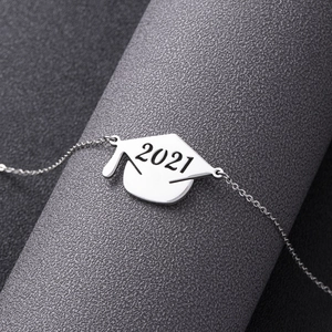 Silver doctoral cap necklace pendant engraved with 2021 on textured display stand