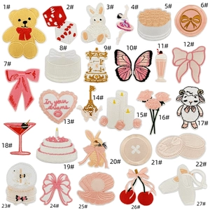 Flat lay of 27 colorful cartoon embroidery patches including bears and hearts