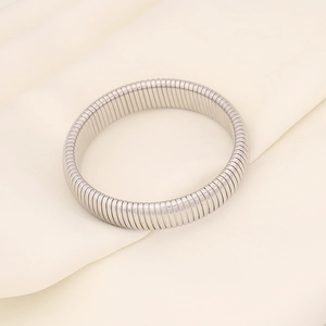 Macro shot of silver elastic steel bracelet with flexible textured snake bone structure