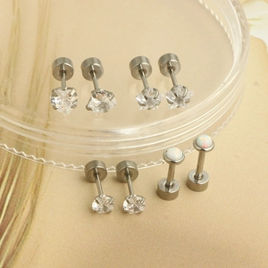 Detail view of four stainless steel stud earring pairs with heart, star, and opal stones