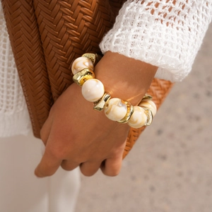 Detail of bohemian resin bead bracelet with marble pattern and golden metal accents