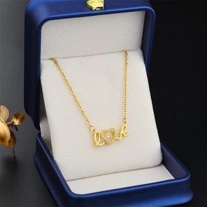 Golden Love heart pendant necklace in a blue jewelry box with elegant gold leaf decor