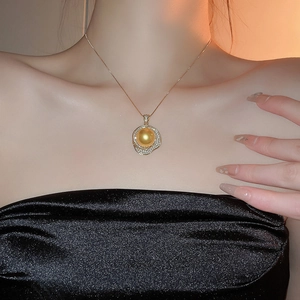 Gros plan sur un collier élégant avec pendentif perle dorée porté par un mannequin