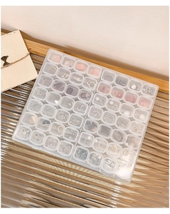 Macro shot of multi-grid clear acrylic jewelry box with frosted lid and earring storage