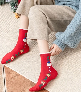 Cozy red Christmas socks with Santa Claus patterns worn in a warm winter holiday scene