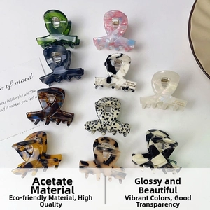 Flat lay of small acetate hair claws in diverse marble, tortoiseshell and checkered patterns