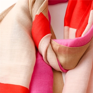 Close-up of lightweight cotton linen scarf with pastel geometric patterns and tassels
